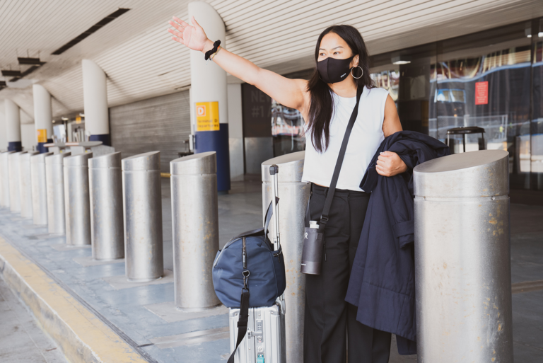 is it safe to travel? woman-in-mask-hails-cab